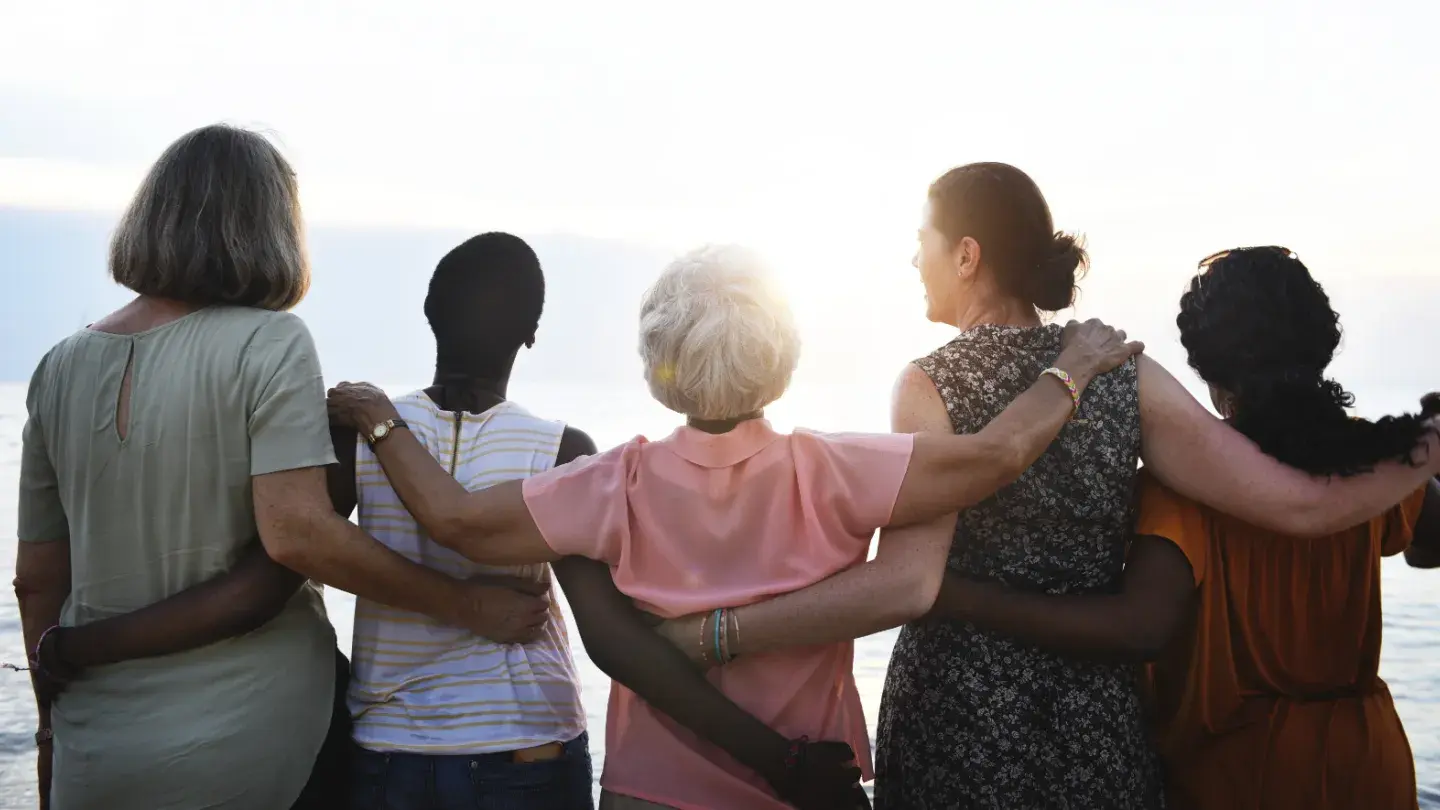 Femmes regardant vers l'horizon, bras dessus, bras dessous